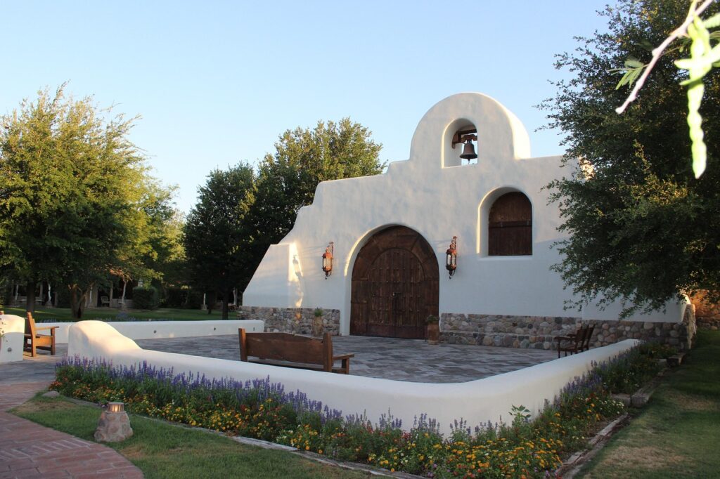 a small chapel with wooden chairs outside during daytime